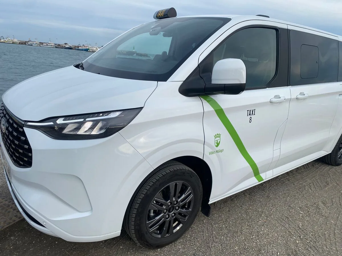 Primer plano del taxi nº 8 con el escudo de Vélez-Málaga, junto al puerto